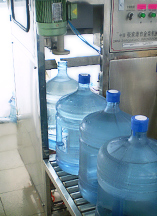 Наполнение питьевой водой бутылей с автоматическим закупориванием